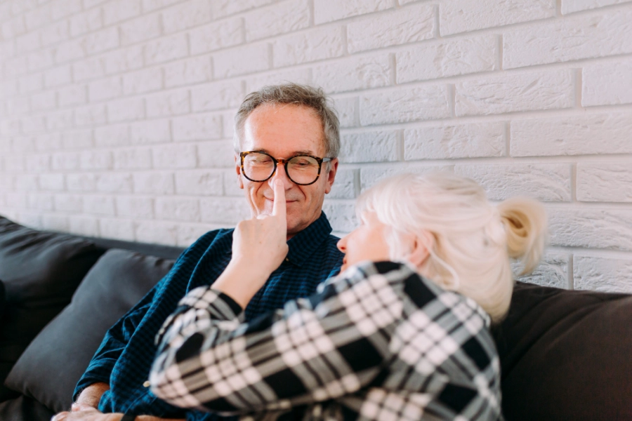 пожилая женщина придерживает пожилого мужчину с заболеванием легких