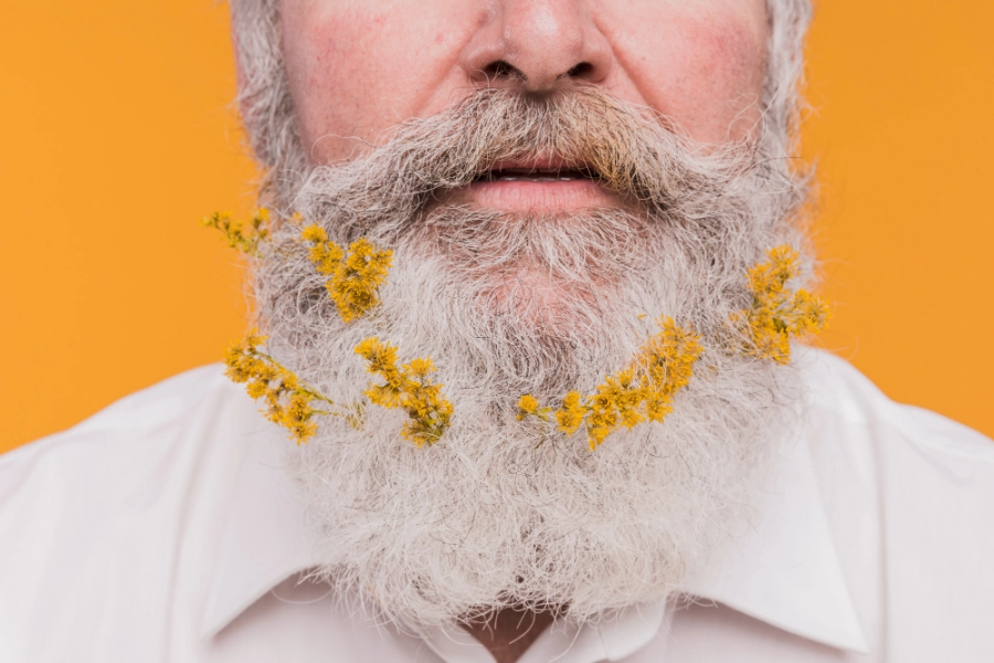 пожилой мужчина с цветами в бороде