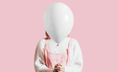 женщина держит в руках надутый воздушный шар