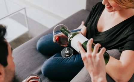 женщина держит бокал алкоголя 