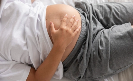 беременная женщина держится за живот из-за болей