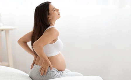 беременная девушка держится за почки